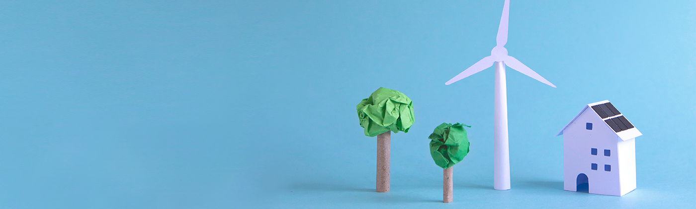 casita de miniatura con dos árboles y un molino de energía eólica