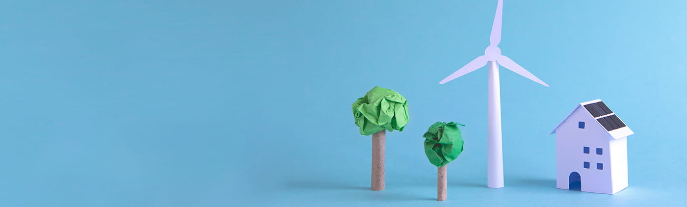 casita de miniatura con dos árboles y un molino de energía eólica